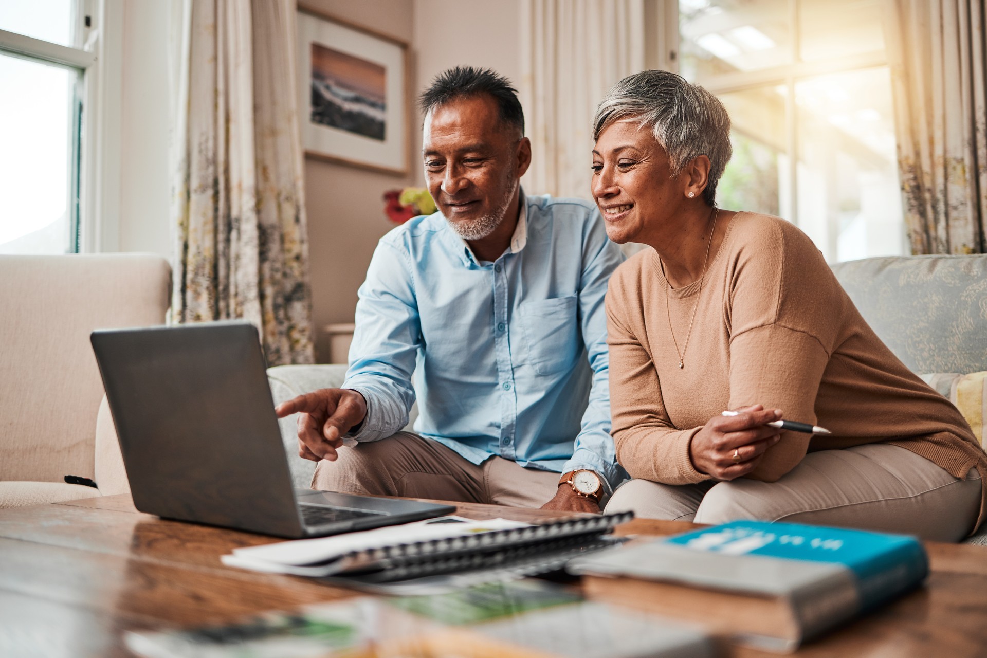 Mature couple, sofa and laptop for planning finance, retirement funding and investment or asset management at home. Elderly people or man and woman reading information on computer for pension savings Mature couple, sofa and laptop for planning finance, retirement funding and investment or asset management at home. Elderly people or man and woman reading information on computer for pension savings
