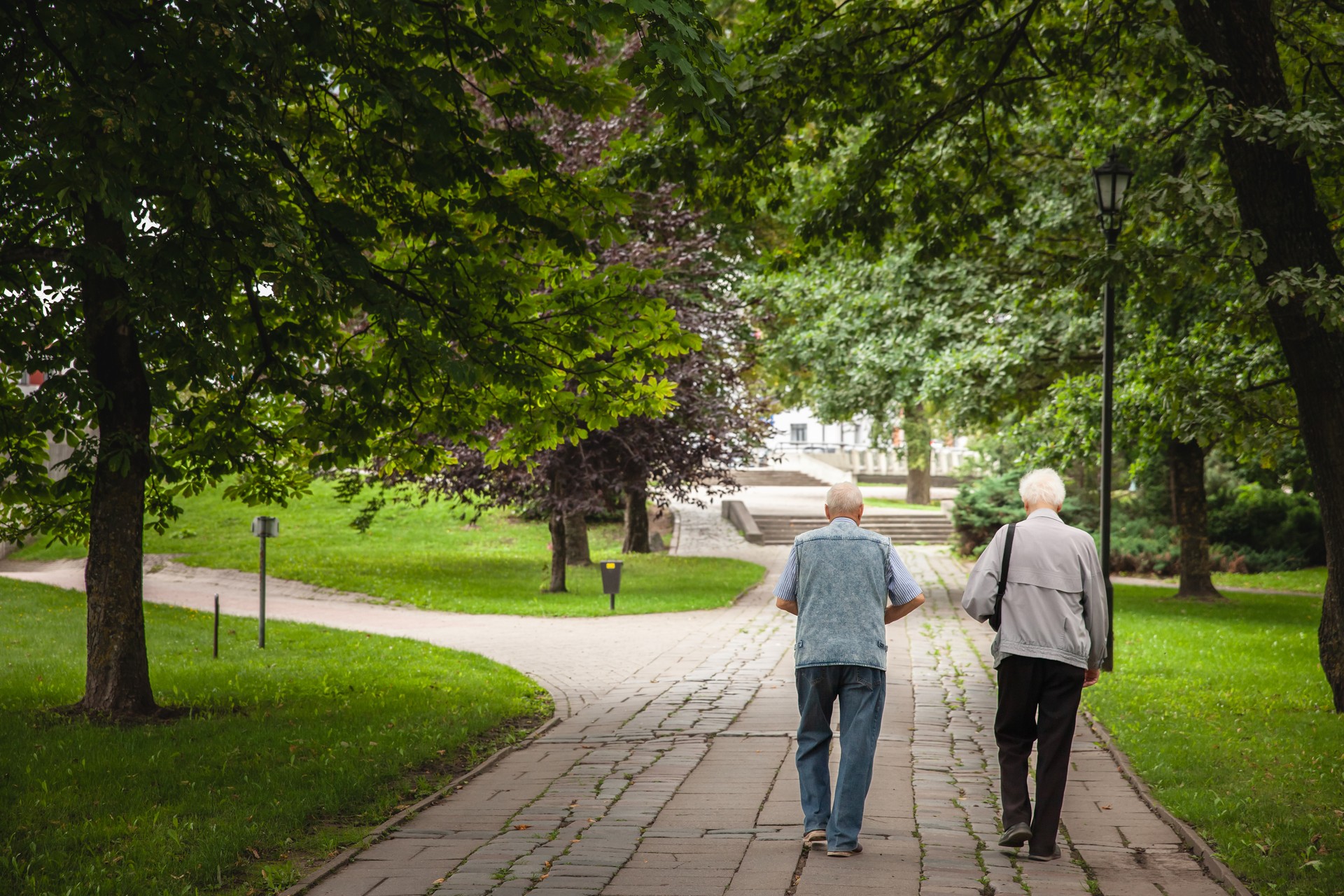 Selective blur on two old men, friends, latvian, walking together in a park in Jelgava in summer. Latvian population is ageing. Selective blur on two old men, friends, latvian, walking together in a park in Jelgava in summer. Latvian population is ageing.