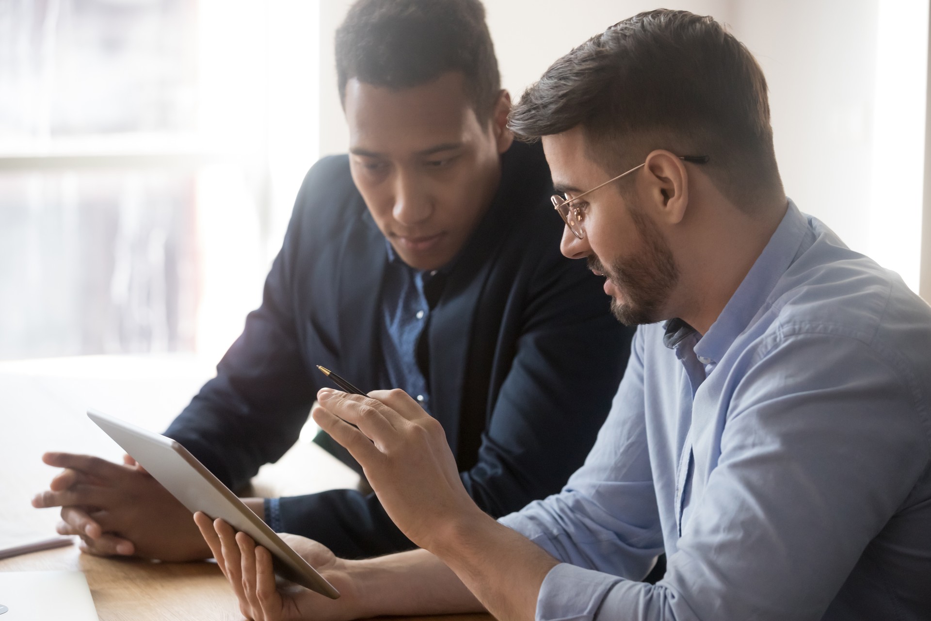 Diverse millennial employees discussing data report at office Diverse millennial employees discussing data report at office